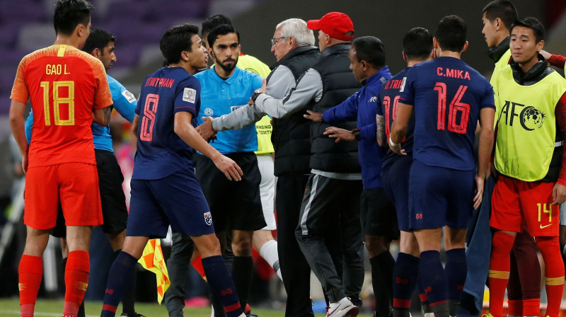 Ķīnas futbola izlases galvenais treneris Marselo Lipi iziet laukumā pēc spēlētāju nekārtībām. Foto: Reuters/Scanpix