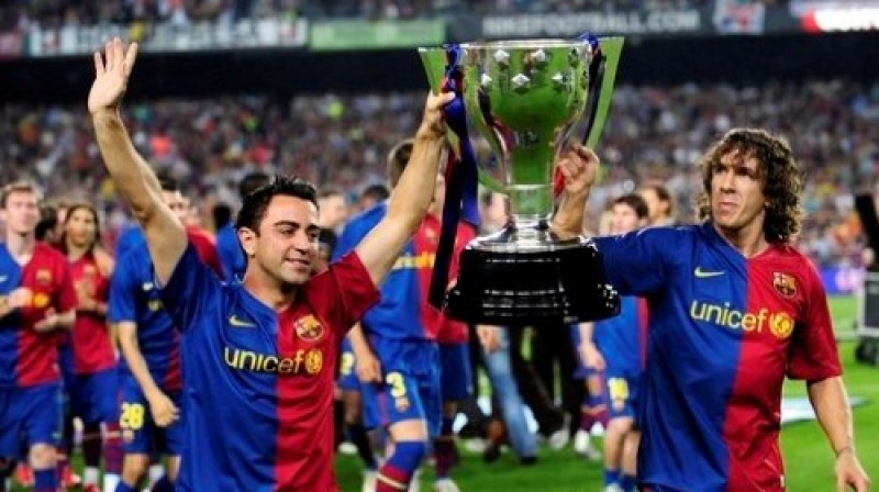 "Barcelona" futbolisti Čavi Ernandess un Karloss Pujols ar pagājušajā sezonā izcīnīto kausu
Foto: AP