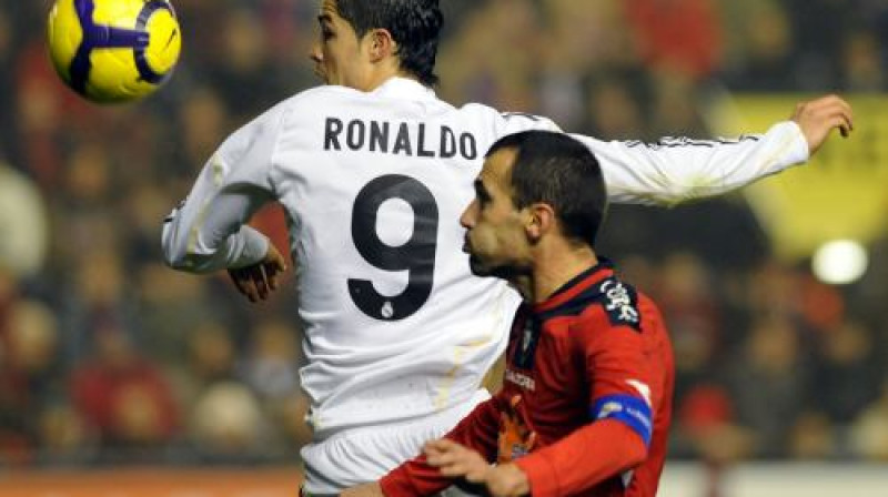 Krištianu Ronaldu ("Real Madrid") gaisa divcīņā pret Pači Punjalu ("Osasuna"). 
Foto: AFP/ Scanpix