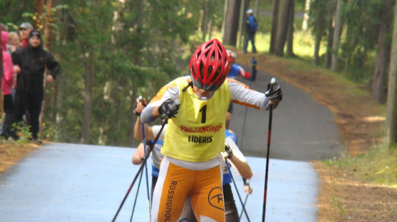 I.Dauškāne ar līderes dzelteno krekliņu un Latvijas slēpošanas izlases atbalstītāja veikala tīkla "FANS" sarūpētajā  "Rossignol" formā. Foto:I.Eglīte