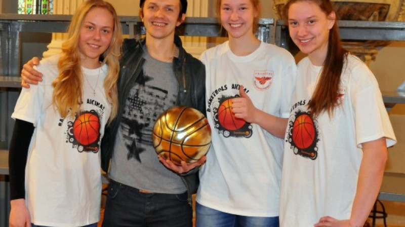 "Rīdzenes" U16 komandas līderes Paula Strautmane (no labās) un Digna Strautmane kopā ar "Prāta Vētras" solistu Renāru Kauperu
Foto: Swedbank LJBL