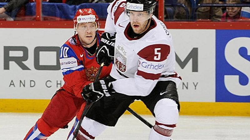 Jānis Sprukts ciešā kontaktā ar Krievijas izlases uzbrucēju Sergeju Mozjakinu. Foto: iihf.com