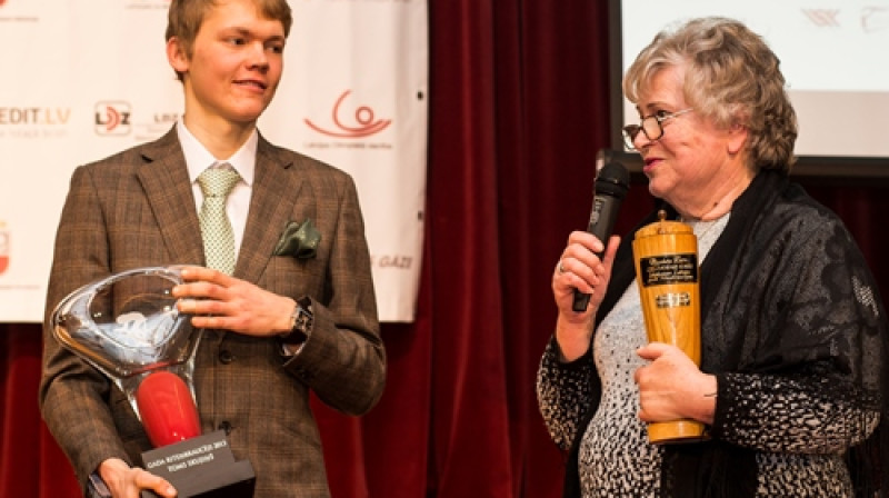 Tomam Skujiņam gada labākā riteņbraucēja ceļojošo balvu pasniedz pirmā latvieša -pasaules čempiona treka riteņbraukšanā  -Dzintara Lāča sieva.
Foto: lrf.lv