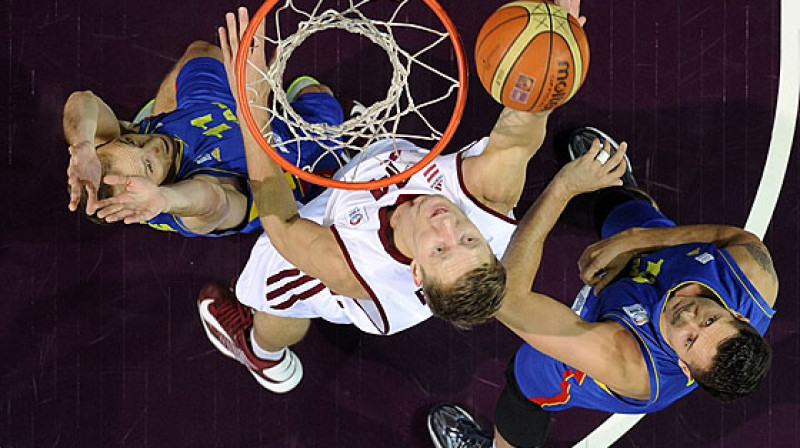 Kaspars Bērziņš cīnās pie Rumānijas izlases groza.
Foto: FIBAEurope (Romāns Kokšarovs)