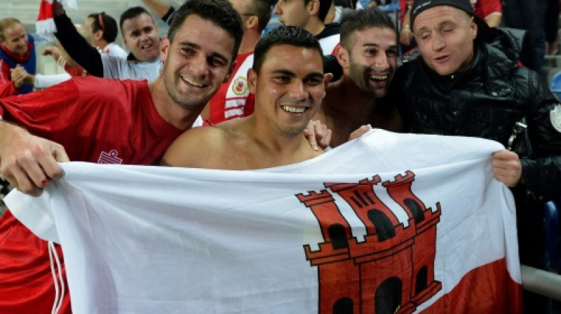 Gibraltāra izlases futbolisti kopā ar līdzjutējiem svin pret Slovākiju izcīnīto 0:0 pirmajā spēlē pēc pievienošanās UEFA saimei
Foto: AFP/Scanpix