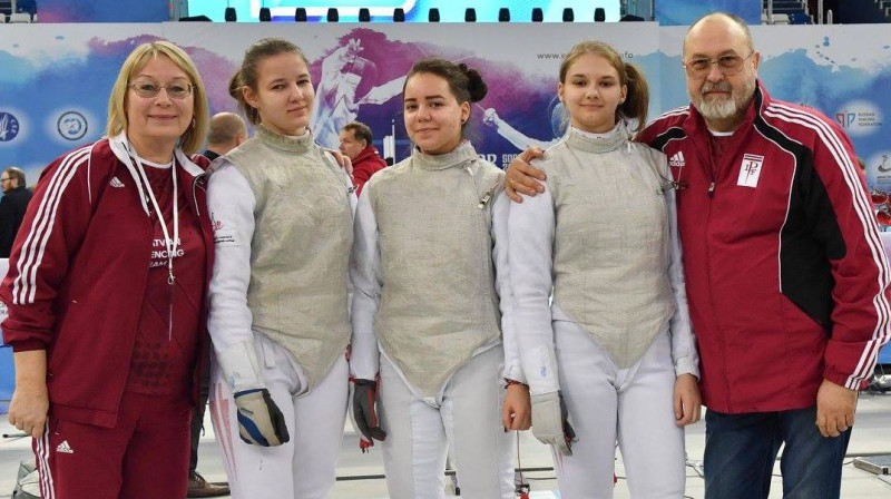 Jekaterina Solodkiha (otrā no kreisās), Emīlija Maslobojeva un Juta Mālniece kopā ar treneriem pēc Eiropas kadetu čempionāta
Foto: Latvijas Paukošanas federācija