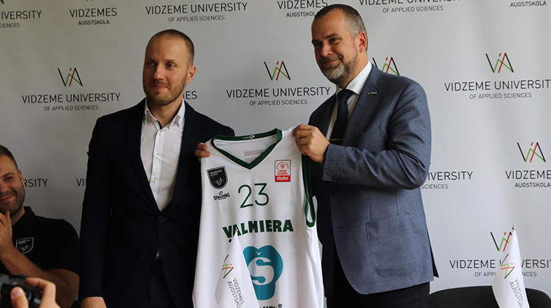 Miks Balodis pasniedz komandas formu Valmieras mēram Jānim Baikam. Foto: Vidzemes Augstskola