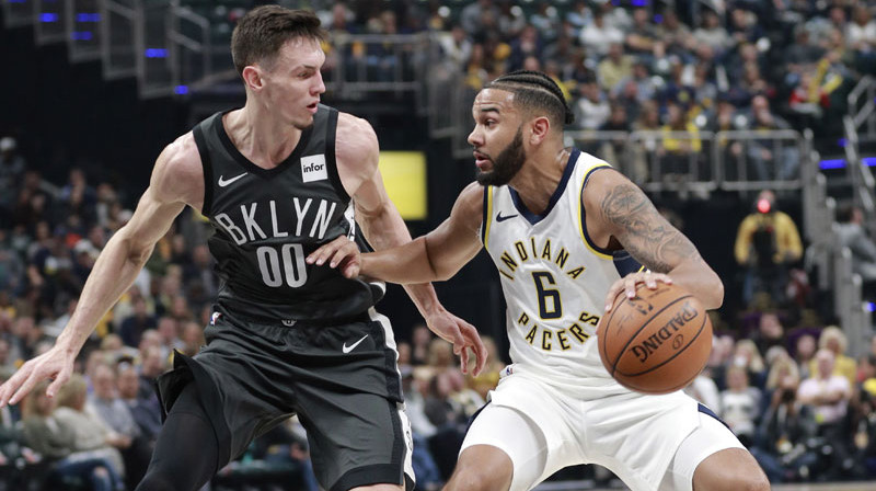 Rodions Kurucs aizsardzībā pret Indiānas "Pacers" aizsargu Koriju Džozefu. Foto: AP/Scanpix