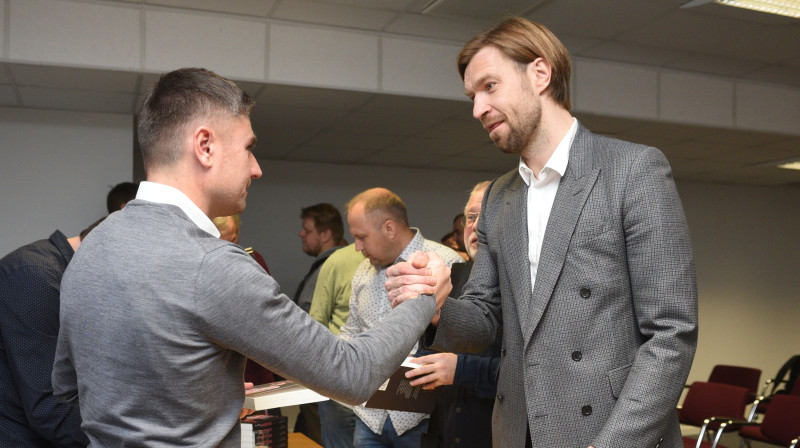 Kaspars Gorkšs sveic Marianu Paharu ar grāmatas iznākšanu. Foto: Romāns Kokšarovs, f64