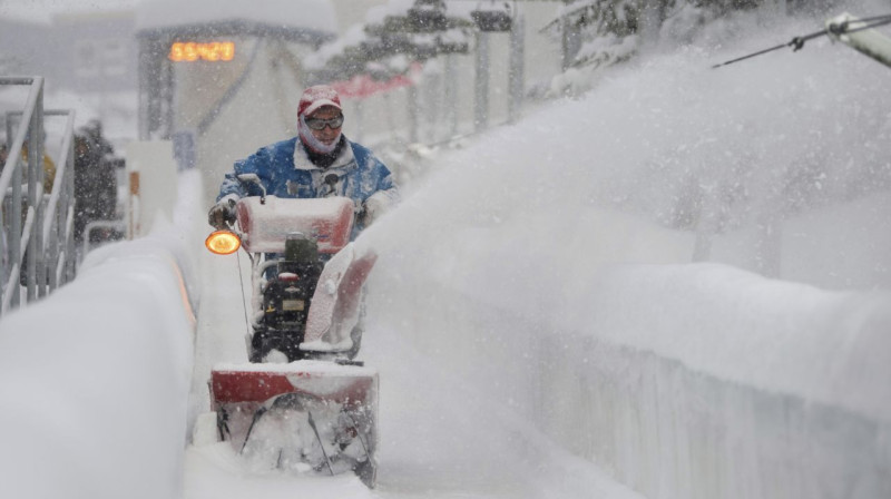Trases darbinieks cenšas uzkopt trasi Altenbergā. Foto: AP / Scanpix