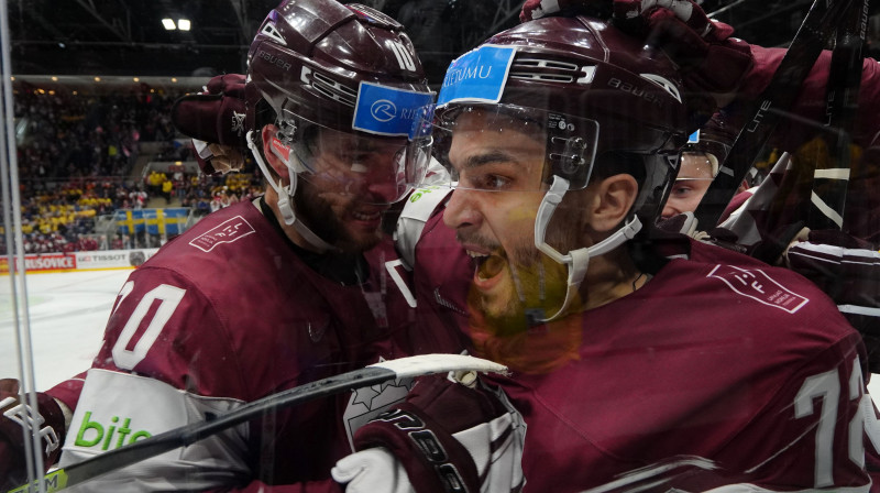 Latvijas hokejisti apsveic Jāni Jaku pēc vārtu guvuma pasaules čempionāta spēlē. Foto: Romāns Kokšarovs/f64