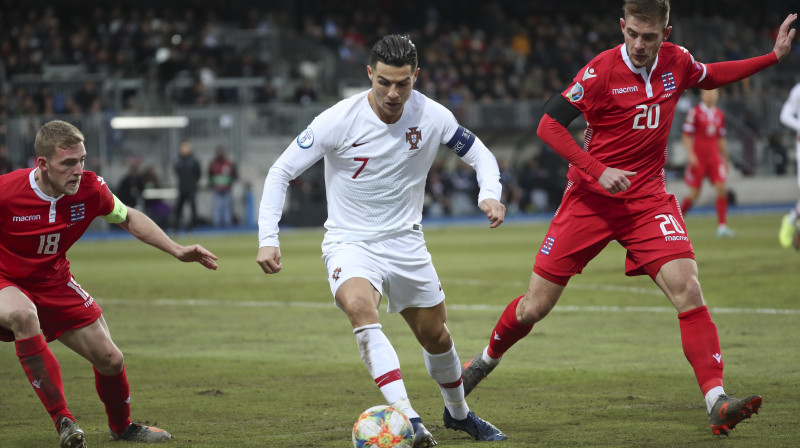 Krištianu Ronaldu ar bumbu Luksemburgas futbolistu ielenkumā. Foto: Francisco Seco/AP/Scanpix