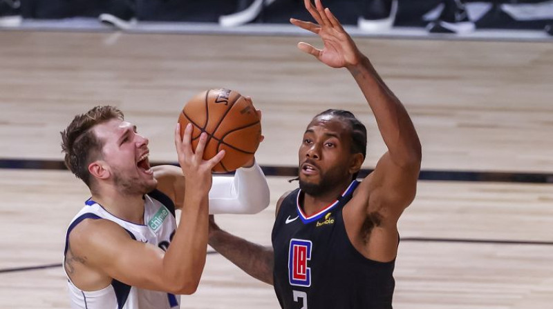 Kavai Lenards (#2) aizsardzībā pret Luka Dončiču (#77). Foto: EPA/Scanpix