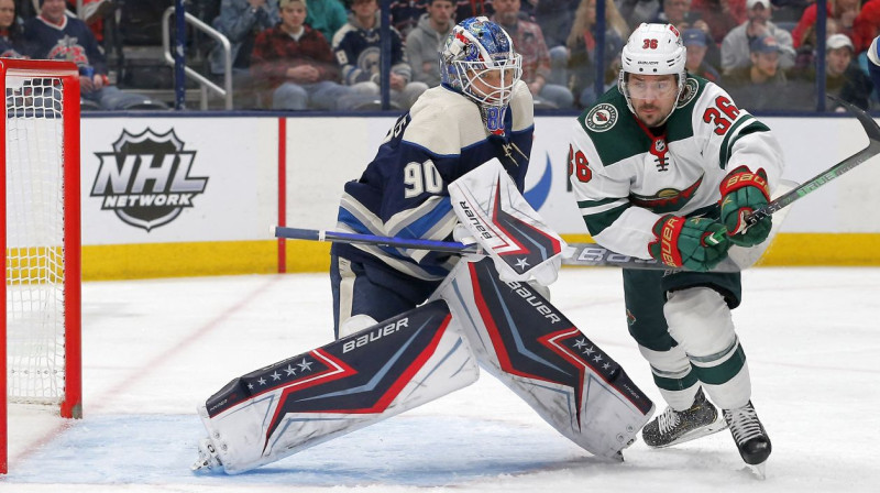 Vārtsargs Elvis Merzļikins un Minesotas "Wild" uzbrucējs Matss Cukarello. Foto: Russell LaBounty/USA Today Sports/Scanpix