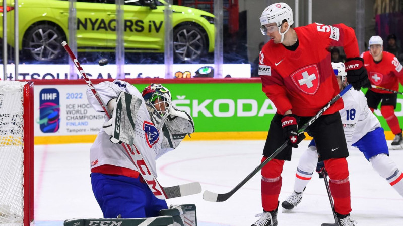 Šveicietis Dario Simions Francijas vārtsarga Sebastjana Ilonena sargāto vārtu priekšā. Foto: Andrea Cardin/HHOF-IIHF Images