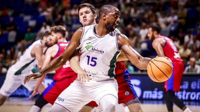 Verners Kohs aizsardzībā pret Malagas "Unicaja" basketbolistu Vilu Tomasu. Foto: FIBA