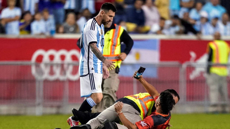 Lionels Mesi un laukumā izskrējis līdzjutējs. Foto: Eduardo Munoz Alvarez/AP/Scanpix