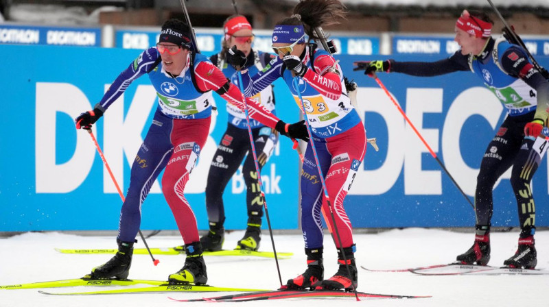 Francijas biatlonisti: Kantēns Fijons-Majē nodod stafeti Anaī Ševaljē-Bušē. Foto: Darko Bandic/AP/Scanpix