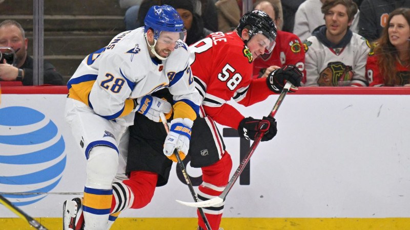 Zemgus Girgensons cīņā pret Čikāgas "Blackhawks" uzbrucēju Makenziju Envislu. Foto: Jamie Sabau/USA Today Sports/Scanpix