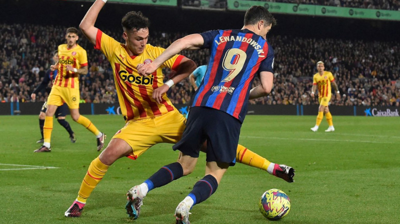 "Girona" futbolists Arnau Martiness aizsardzībā pret "Barcelona" līderi Robertu Levandovski. Foto: Pau Barrena/AFP/Scanpix