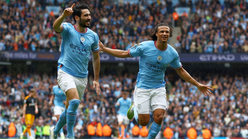 No kreisās: Mančestras "City" futbolisti Ilkajs Gindogans un Neitans Akē. Foto: Lee Smith/Reuters/Scanpix