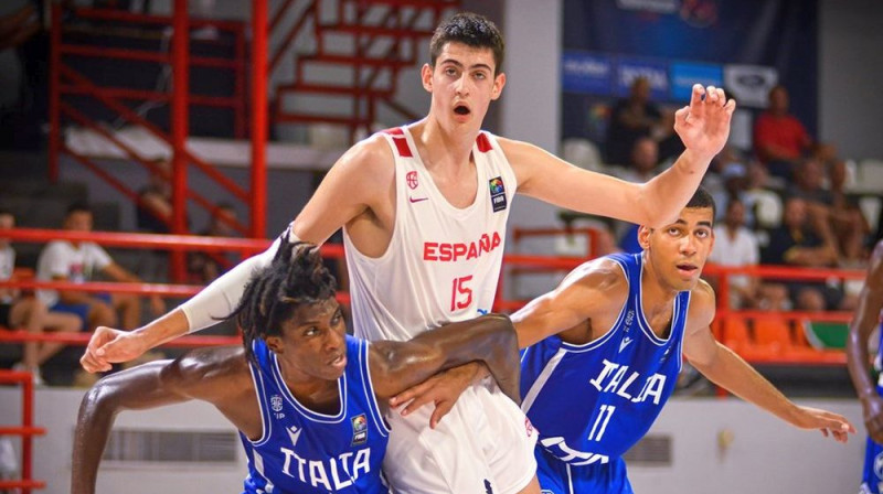 Spānijas U18 basketbolists Adajs Mara Itālijas spēlētāju ielenkumā. Foto: FIBA