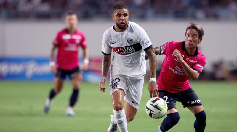 PSG futbolists Levēns Kurzava cīņā par bumbu ar Osakas "Cerezo" spēlētāju Riku Macudu. Foto: Paul Miller/AFP/Scanpix