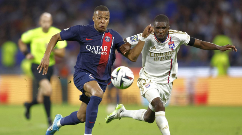 Kiljans Mbapē (PSG) cīņā par bumbu pret Klintonu Matu ("Lyon"). Foto: Gonzalo Fuentes/Reuters/Scanpix