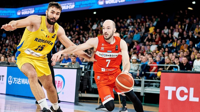 Luksemburgietis Filips Gūtenkaufs ar bumbu cīņā pret rumāni Emanuelu Kati. Foto: FIBA