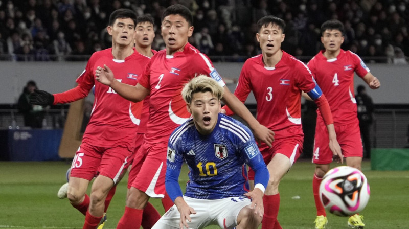 Japānis Ricu Doans un Ziemeļkorejas valstsvienības futbolisti. Foto: Franck Robichon/EPA/Scanpix