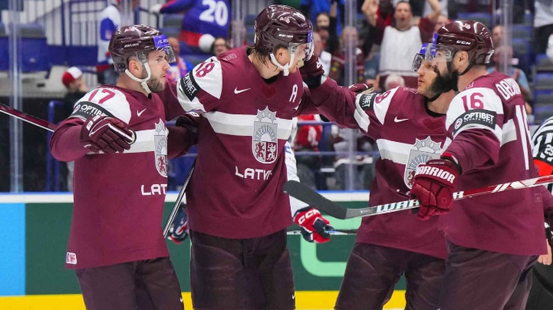 Mārtiņš Dzierkals ar komandas biedriem atzīmē vārtu guvumu. Foto: Matt Zambonin/IIHF