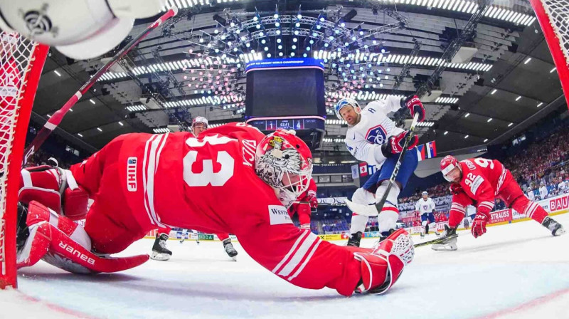 Polijas valstsvienības vārtsargs Tomāšs Fučīks tver Francijas hokejista Stefāna Da Kostas metienu. Foto: Matt Zambonin/IIHF