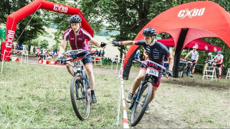 Mārtiņš Linde (pa kreisi) nodod stafeti Andrim Sarksņam. Foto: LOF.