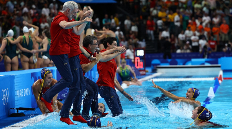 Spānijas sieviešu ūdenspolo valstsvienības treneri pēc triumfa Parīzes olimpiskajās spēlēs lēca baseinā. 
Foto: Evgenia Novozhenina/Reuters/Scanpix