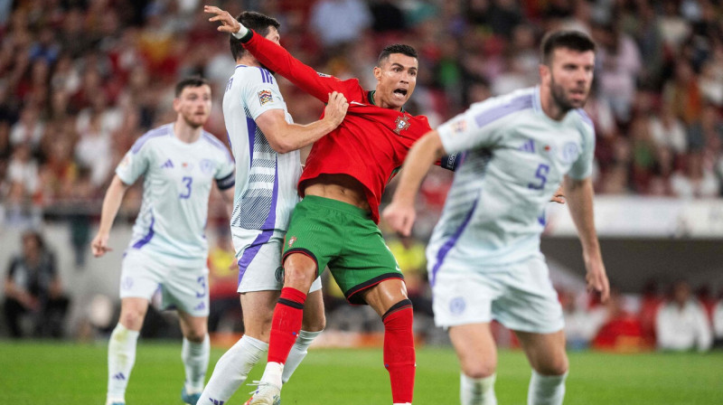 Krištianu Ronaldu cīņā pret Skotijas futbolistiem. Foto: Patricia de Melo Moreira/AFP/Scanpix