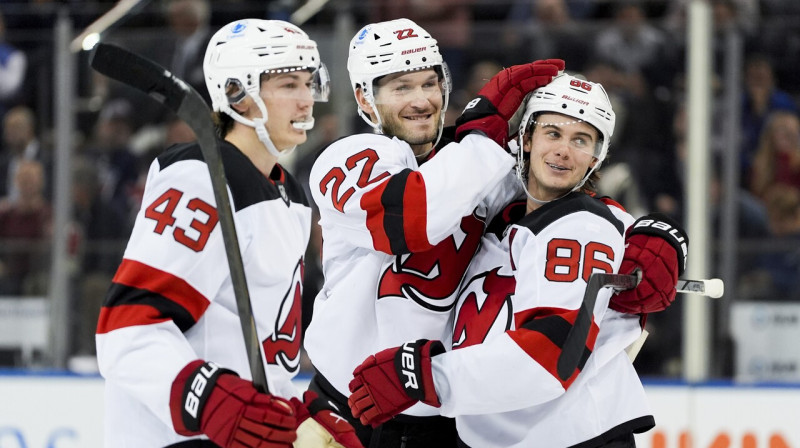 Ņūdžersijas "Devils" aizsargi Lūks Hjūzs (Nr. 43) un Brets Pešs (Nr. 22) sveic Džeku Hjūzu (Nr. 86) pēc vārtu guvuma.
Foto: Julia Demaree Nikhinson/AP/Scanpix