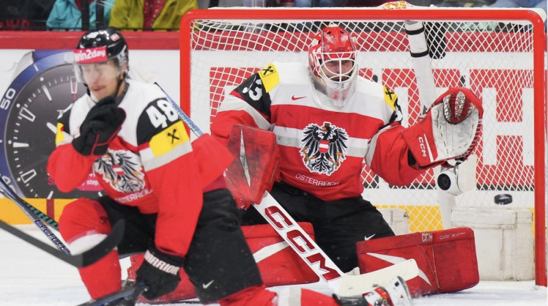 Austrijas vārtu vīrs Florians Forauers un uzbrucējs Lukass Talers. Foto: IIHF