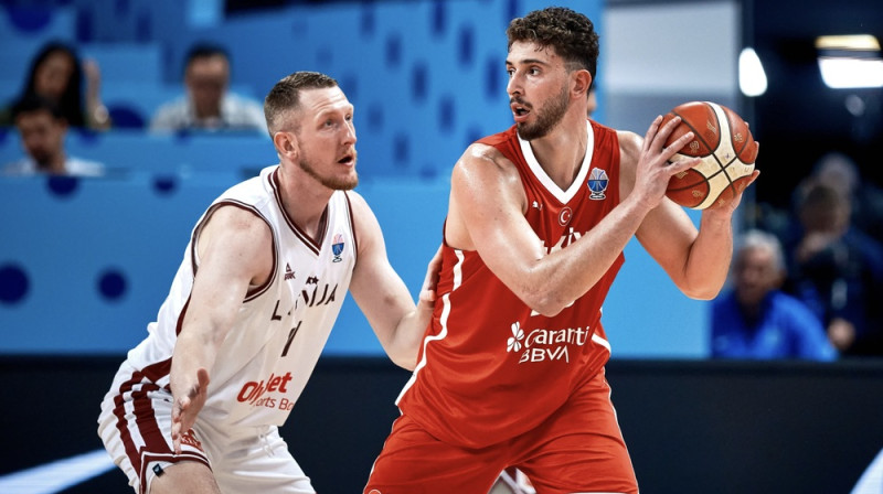 Rolands Šmits aizsardzībā pret Alperenu Šenginu. Foto: FIBA