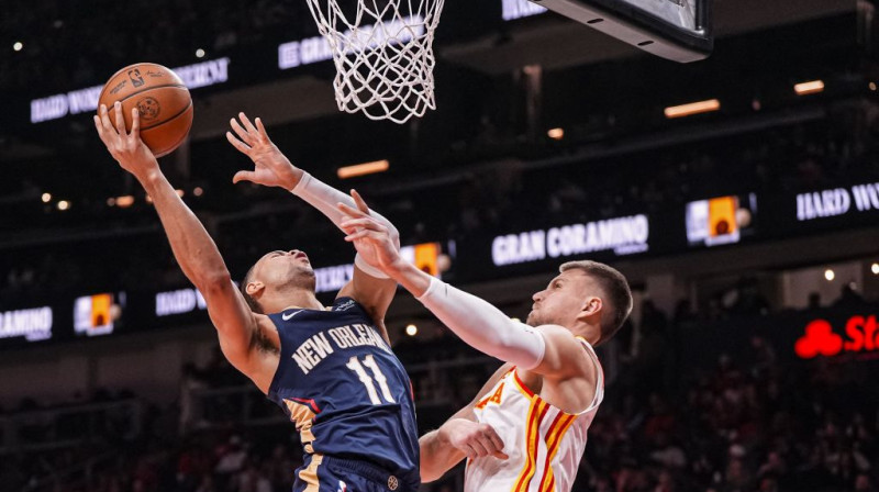 Kirstaps Porziņģis sava groza apakšā cīnās pret Braisu Makgouvenu. Foto. AP. Scanpix