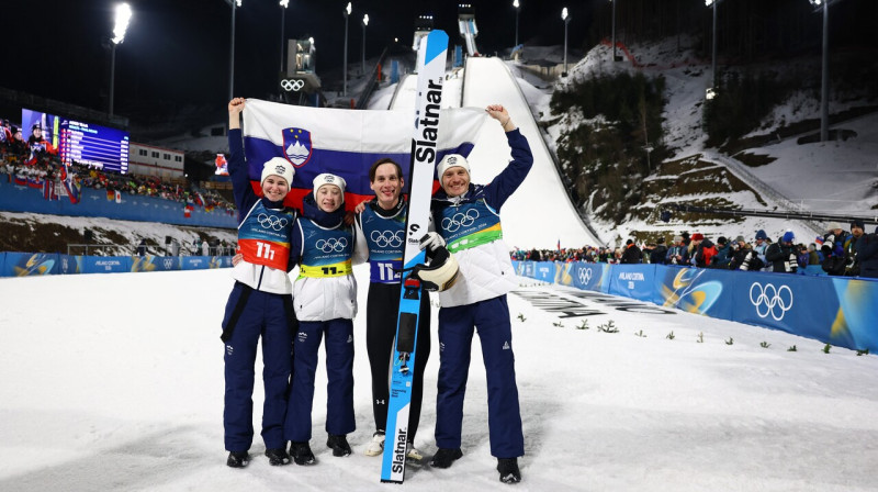 No kreisās: Slovēnijas tramplīnlēcēji Nika Vodana, Nika Prevca, Domens Prevs un Anže Lanišeks pēc triumfa jaukto komandu olimpiskajās sacensībās Predaco. Foto: Kai...
