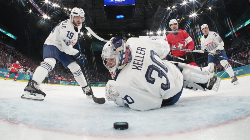 Mirklis pirms Šveices valstsvienības pirmā vārtu guvuma cīņā pret Franciju – Damjēna Riata raidītā ripa traucas Antuāna Kellera cietoksnī. 
Foto: Mike Segar/AP/Scanpix