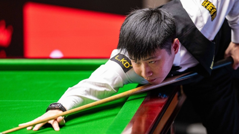 Sjiņtuns Džao gatavojas sitiena veikšanai pasaules čempionāta otrās kārtas spēlē pret Dzjuņhui Dinu. Foto: Godfrey Pitt/IMAGO/Action Plus/Scanpix