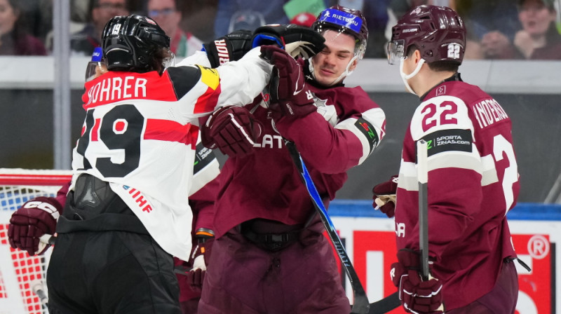 Artūrs Andžāns cīņā ar Austrijas hokejistu. Foto: IIHF