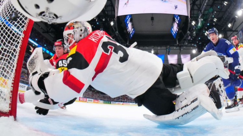 Dāvids Kikerts nepagūst izglābt pēc Mikaela Granlunda metiena tukšā stūrī. Foto: IIHF