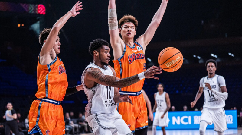 Kigali "RSSB Tigers" vilcējspēks Kreigs Rendals Šanhajas "Sharks" basketbolistu ielenkumā. Foto: FIBA